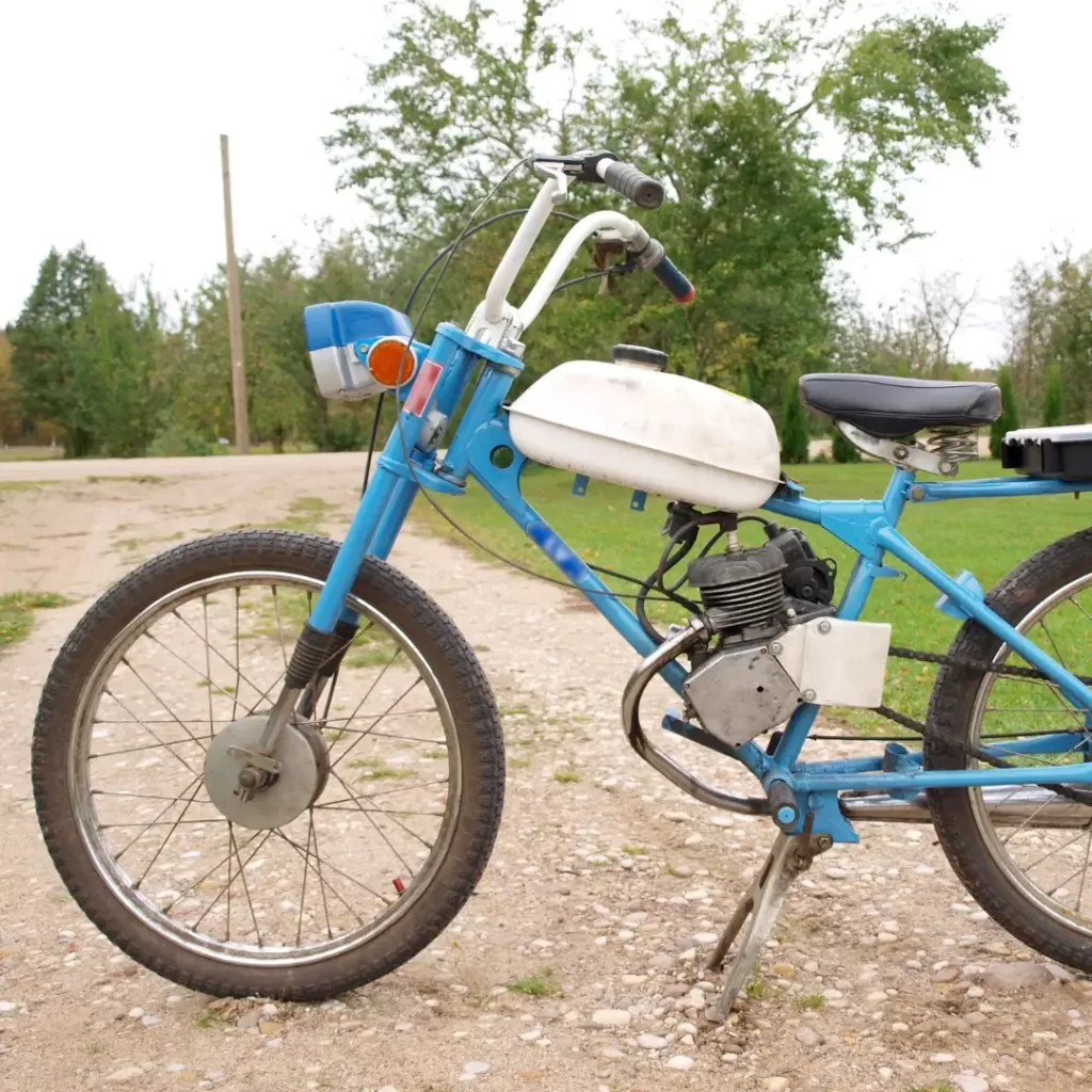 Bicimoto retro de color celeste con manivela blanca