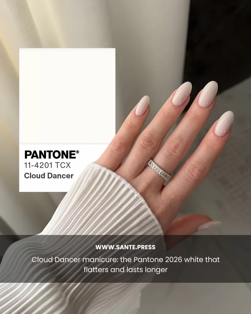 Hand with milky white “Cloud Dancer” manicure (Pantone 11-4201 TCX), glossy almond-shaped nails and a silver ring; text about the Pantone 2026 white that elongates the fingers and lasts longer.