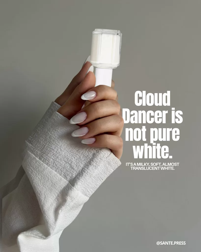 Hand with translucent white nails holding a clear nail polish bottle; text explains that Cloud Dancer is not pure white but milky, soft, and almost transparent.