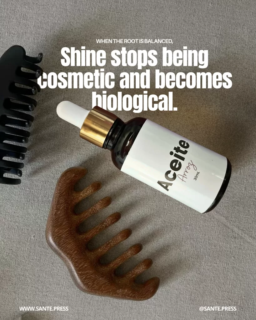 Dropper bottle of hair oil next to a wooden comb on a neutral textile surface, products for scalp massage, deep hydration, and anti-frizz treatment.