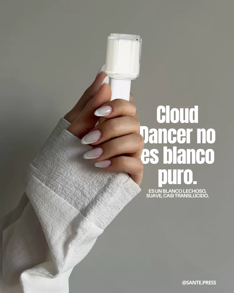 Mano con uñas blanco translúcido sosteniendo un frasco de esmalte claro; texto explica que Cloud Dancer no es blanco puro sino lechoso, suave y casi transparente.