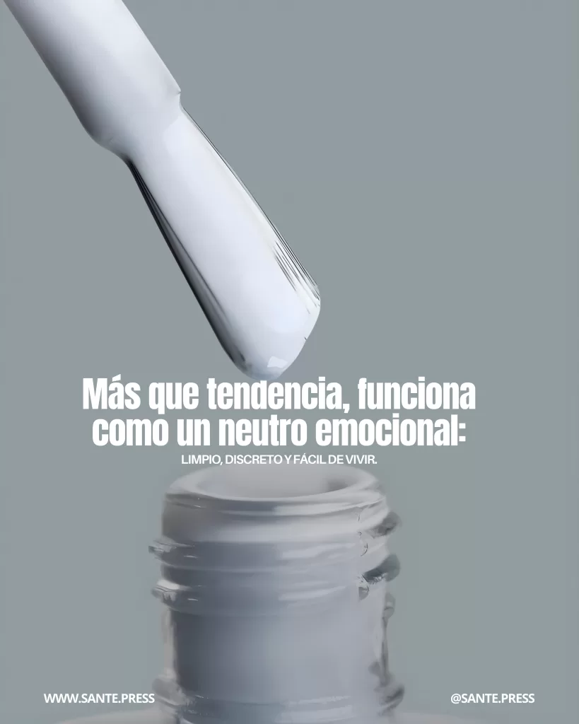 Gota de esmalte blanco cayendo hacia un frasco sobre fondo gris azulado; texto indica que funciona como un neutro emocional limpio, discreto y fácil de vivir.