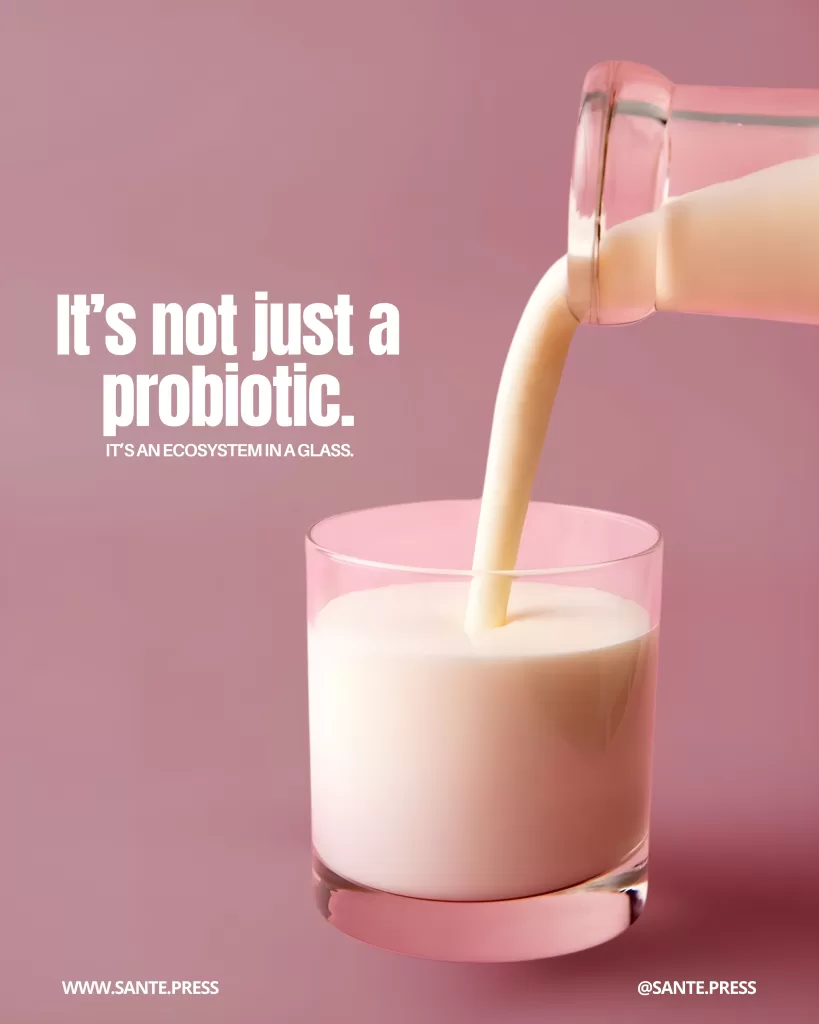 Kefir being poured into a glass against a pink background. Text: “It’s not just a probiotic. It’s an ecosystem in a glass.”