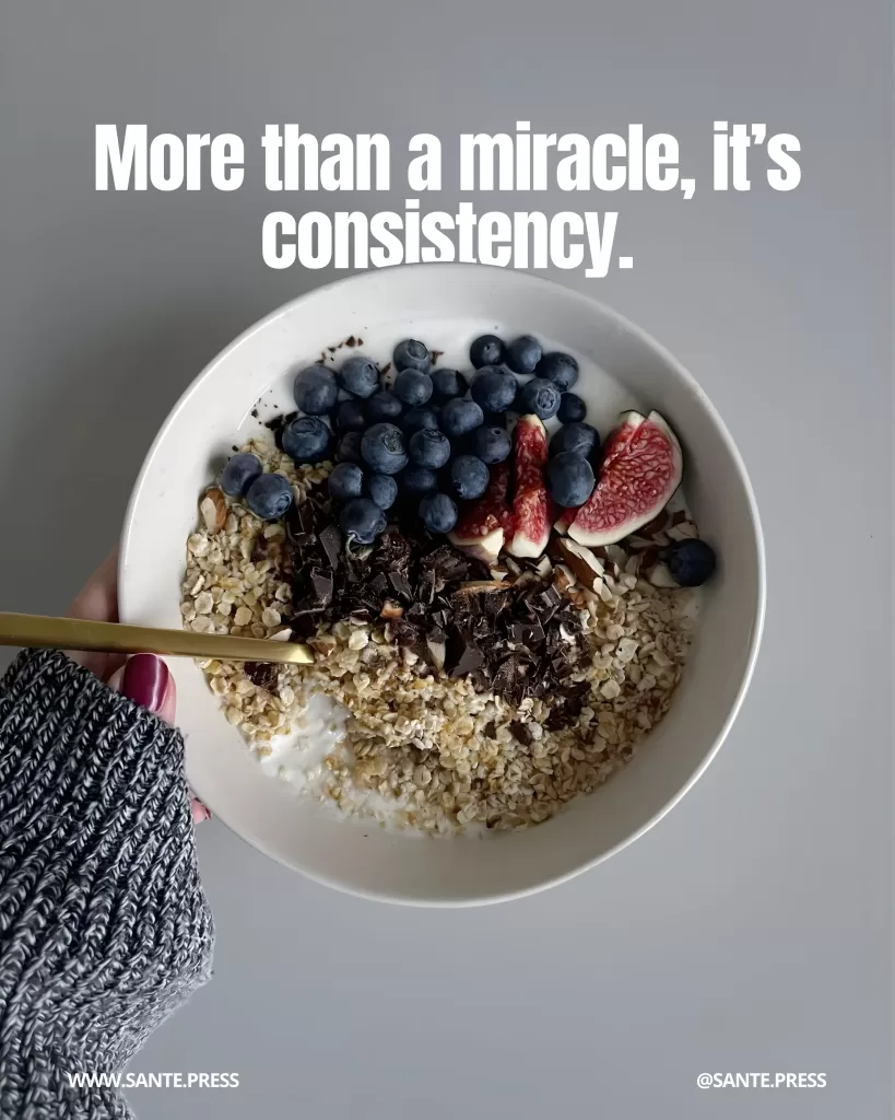 Bowl with yogurt or kefir topped with oats, blueberries, figs, and grated chocolate. Text: “More than a miracle, it’s consistency.”